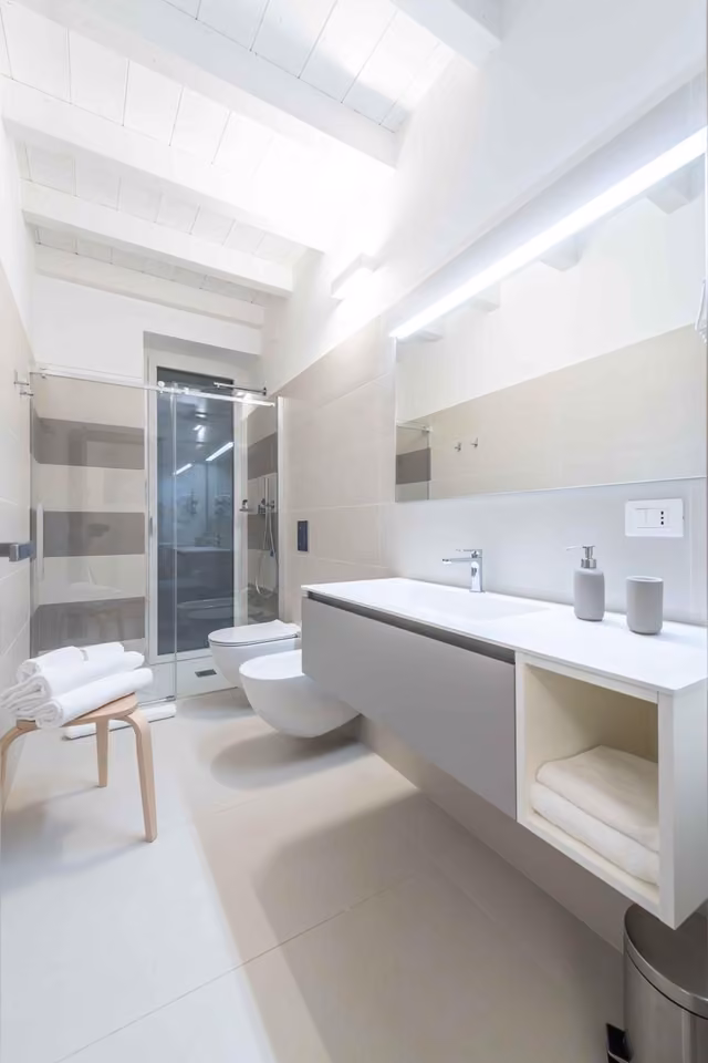 Bagno bianco con due lavandini e WC de Le Dimore a Ortona